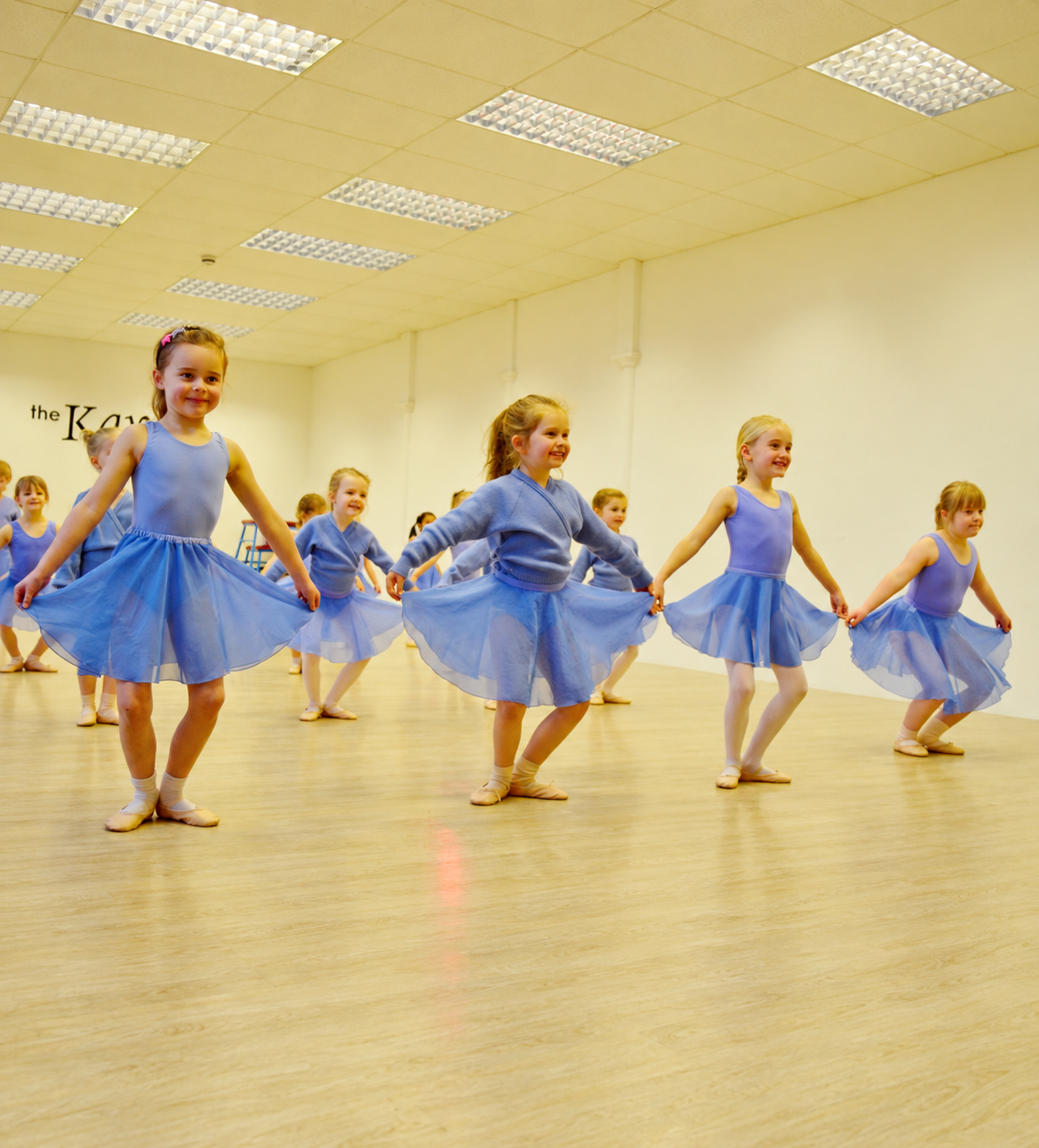 Young Kay Academy ballet dancers practising together in blue dresses